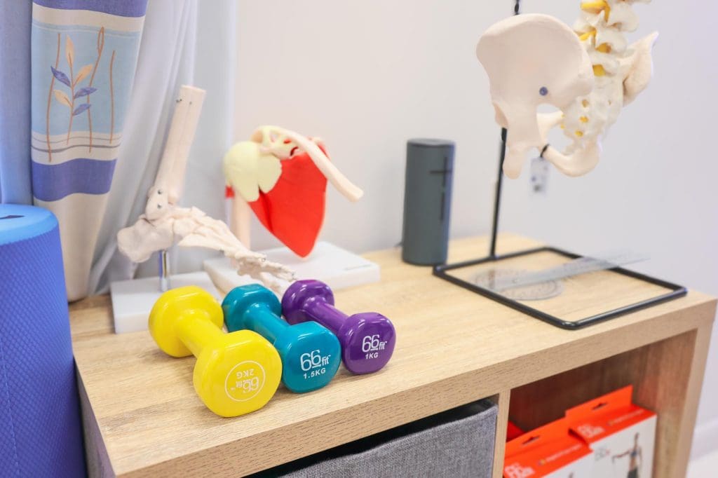 Physiotherapist guiding client through a standing posture assessment in clinic