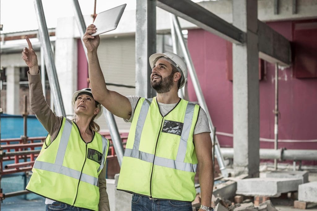 Woman in protective workwear including hard hat and safety vest on a construction site