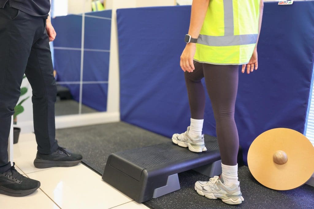 Patient receiving hands‑on assessment or treatment from a physiotherapist in a clinical setting